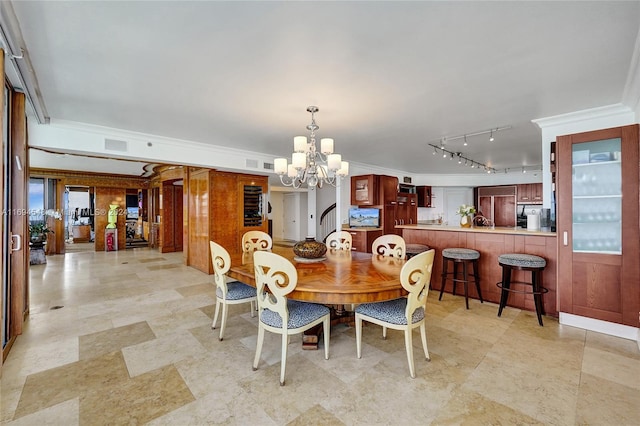 dining space featuring a wealth of natural light, an inviting chandelier, and ornamental molding