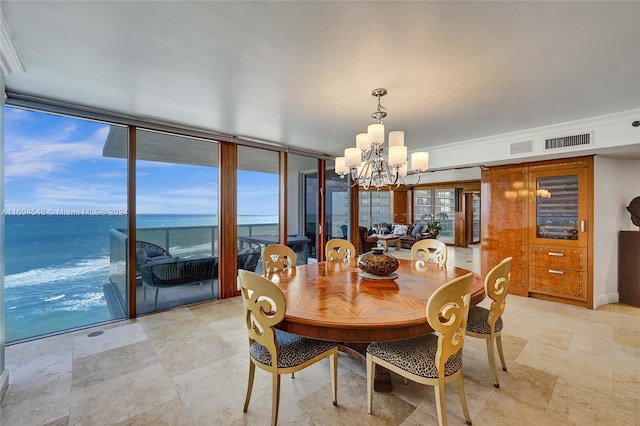 dining room featuring expansive windows, a water view, and an inviting chandelier