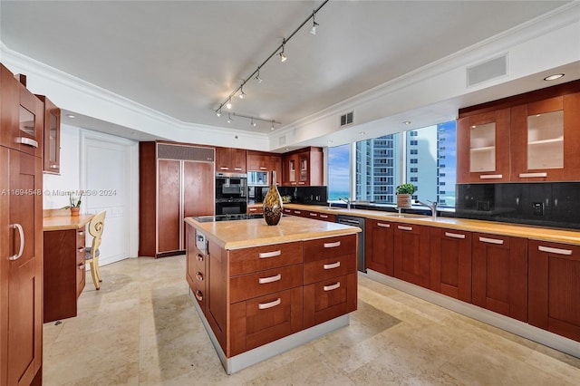 kitchen with backsplash, paneled built in refrigerator, a kitchen island, and ornamental molding