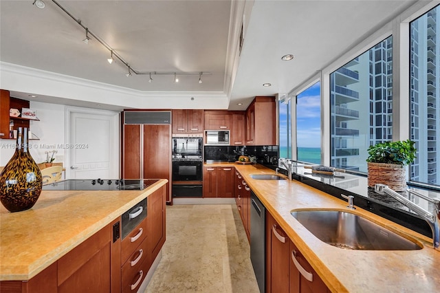 kitchen featuring black appliances, a water view, sink, and tasteful backsplash