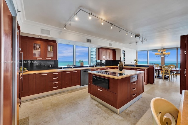 kitchen with dishwasher, a center island, an inviting chandelier, a water view, and decorative backsplash