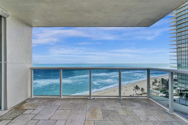 balcony featuring a water view and a view of the beach