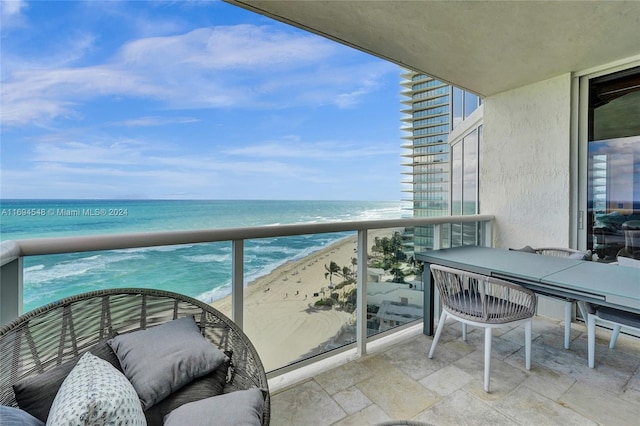 balcony featuring a water view and a beach view