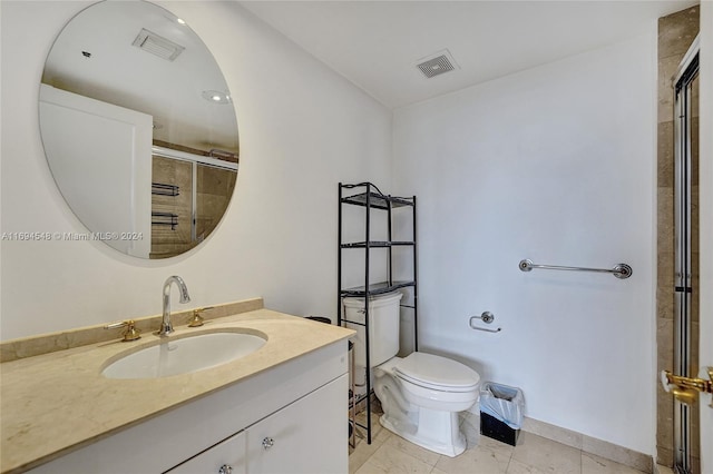 bathroom with vanity, toilet, and a shower with door