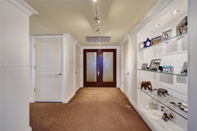 carpeted foyer entrance with french doors and crown molding