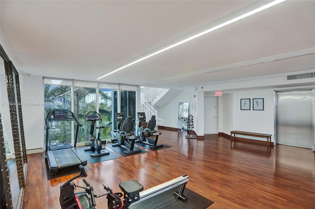 exercise room featuring expansive windows, dark wood-type flooring, and elevator