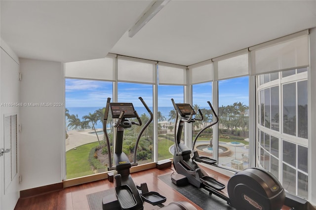 interior space with dark hardwood / wood-style floors, a wall of windows, and a water view