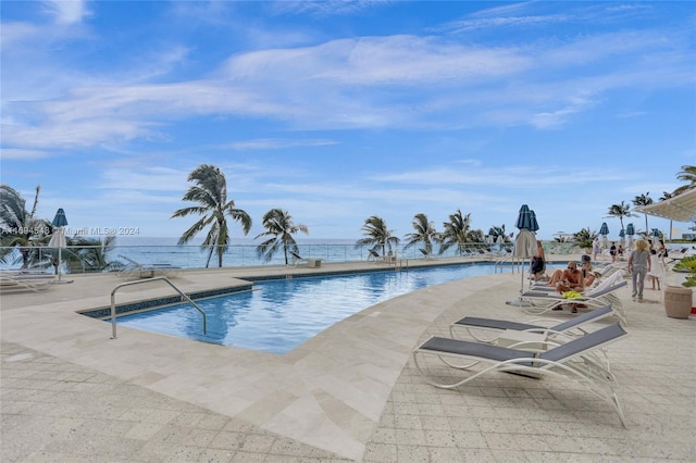 view of swimming pool featuring a patio area and a water view