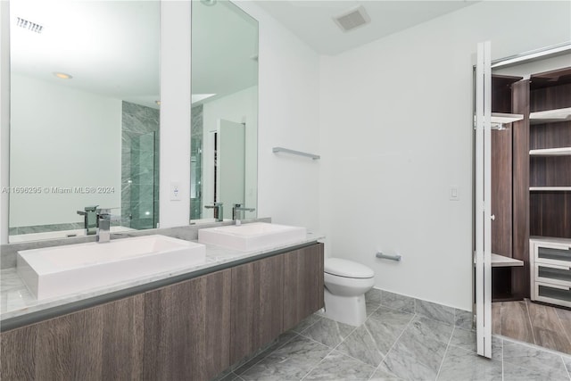 bathroom featuring vanity, toilet, and a shower with shower door