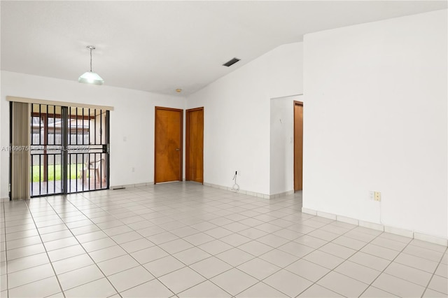 tiled spare room with vaulted ceiling