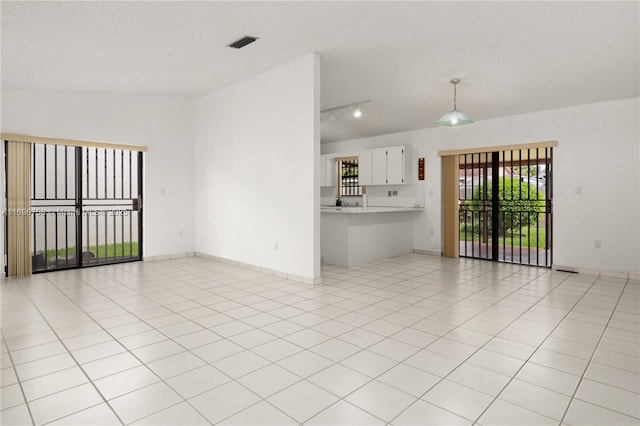 interior space with a textured ceiling and light tile patterned flooring