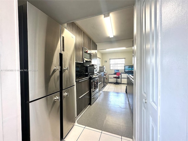 kitchen featuring light tile patterned floors, dark brown cabinetry, and stainless steel appliances