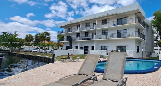 view of pool featuring a patio and a water view