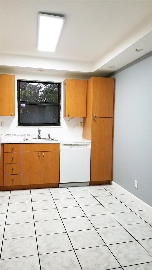 kitchen with sink, white dishwasher, and light tile patterned flooring