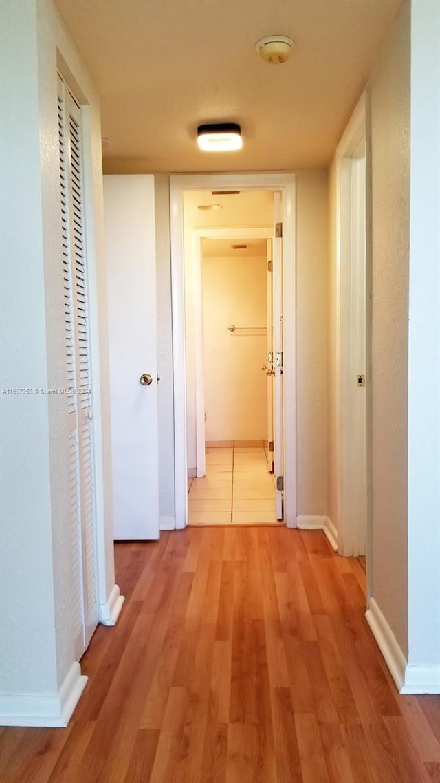 hallway with hardwood / wood-style flooring