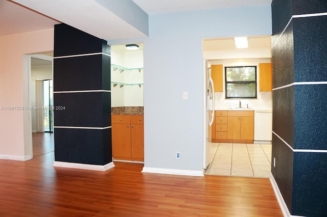 kitchen featuring light hardwood / wood-style floors, white appliances, and sink