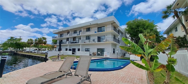 view of pool featuring a water view and a patio area