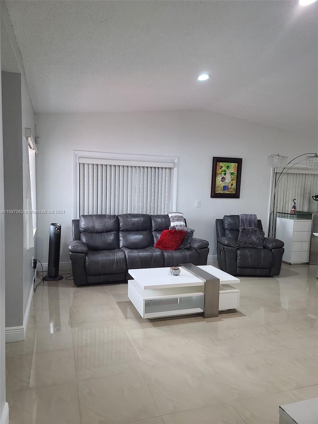 living room with a textured ceiling and vaulted ceiling