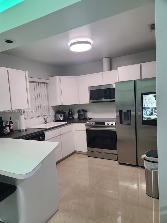 kitchen with white cabinets, appliances with stainless steel finishes, and sink