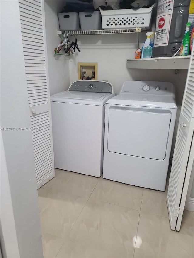 washroom featuring washer and dryer and light tile patterned floors