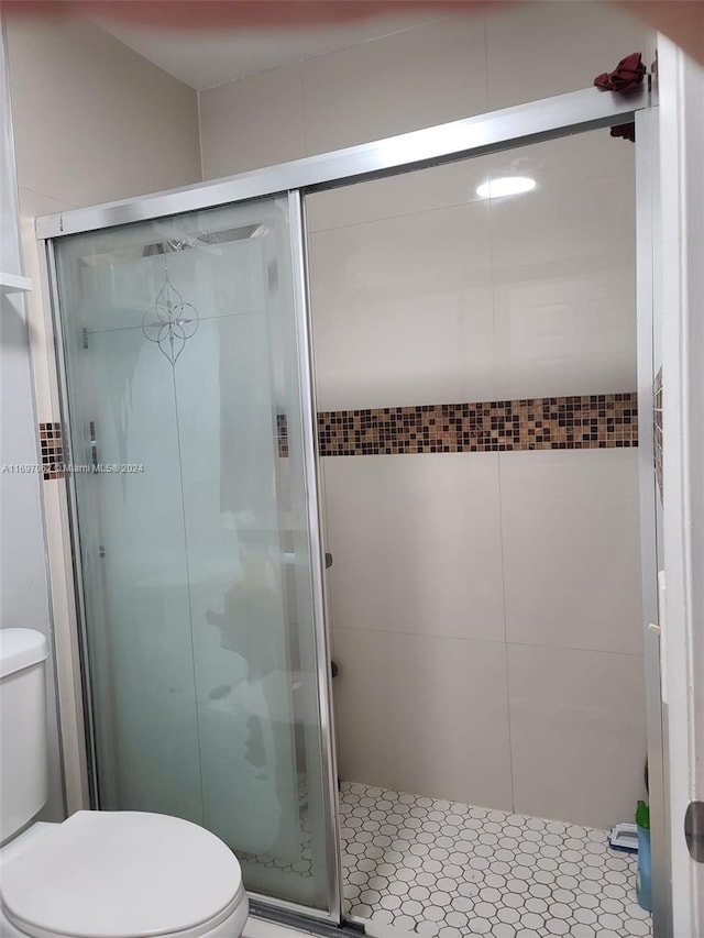 bathroom with an enclosed shower and toilet