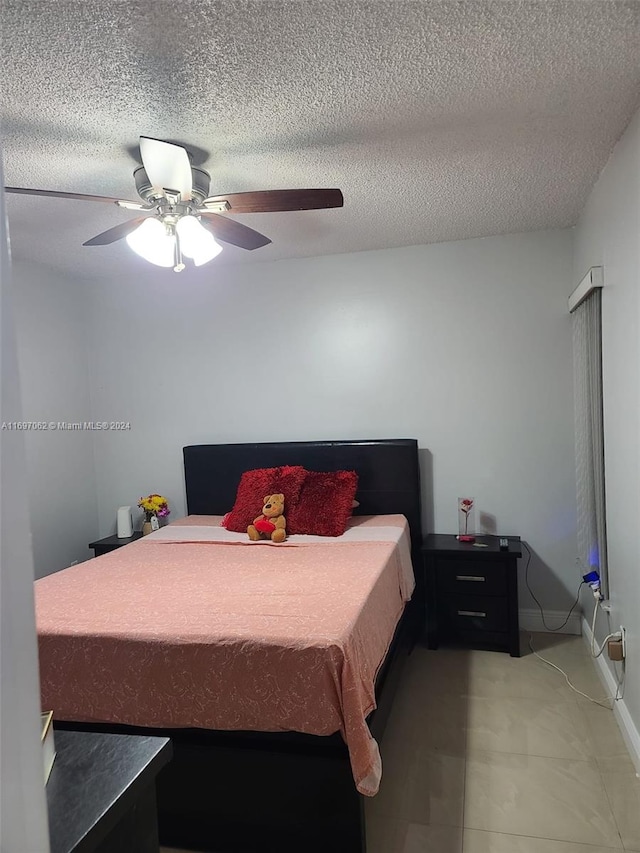 bedroom with ceiling fan and a textured ceiling