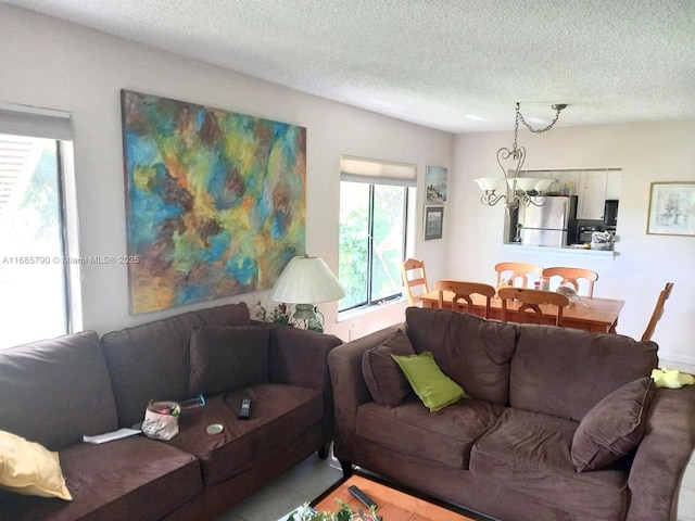 living area with a textured ceiling and an inviting chandelier