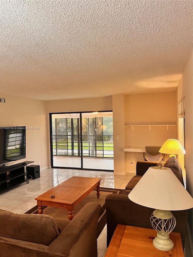 living room featuring visible vents, a textured ceiling, baseboards, and light tile patterned floors