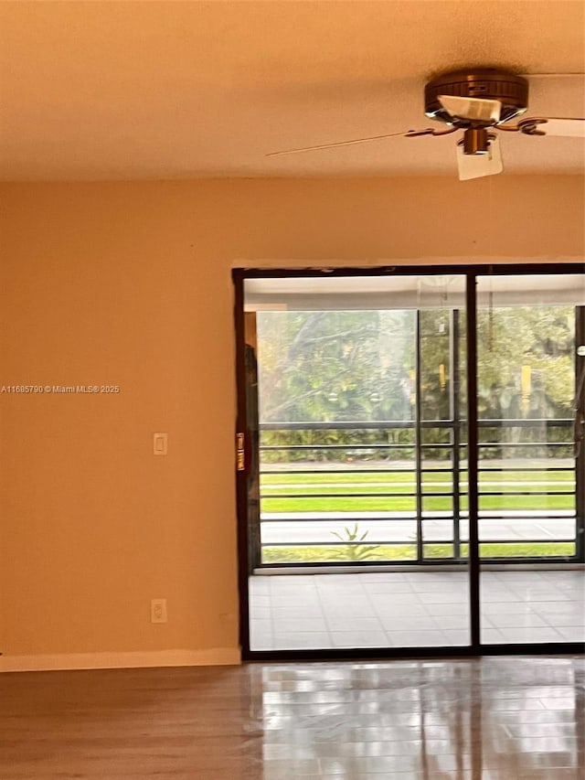 doorway to outside featuring ceiling fan and baseboards