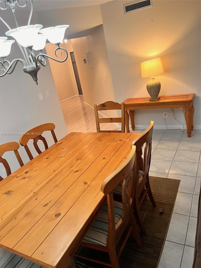 dining area with an inviting chandelier and light tile patterned floors