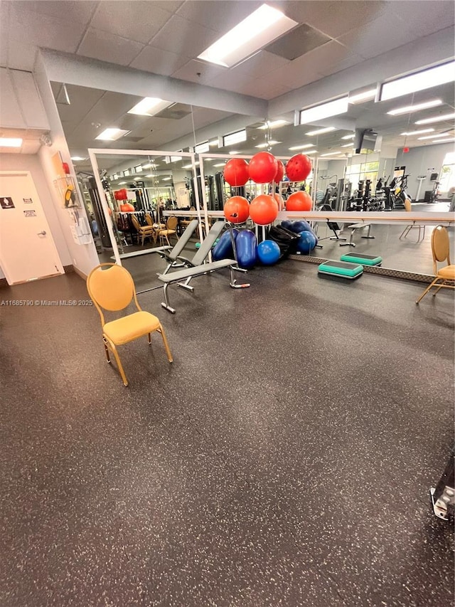 gym with a paneled ceiling