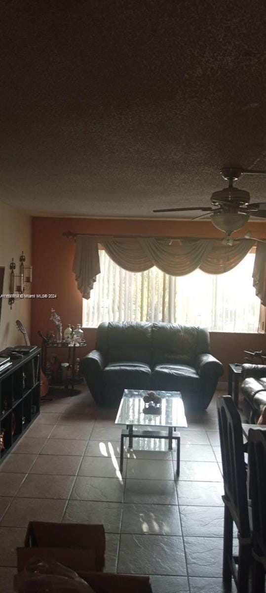 living room featuring ceiling fan, light tile patterned floors, and a wealth of natural light