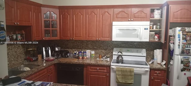 kitchen featuring stone counters, white appliances, and backsplash