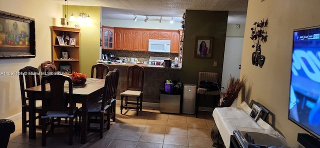 tiled dining area with a textured ceiling