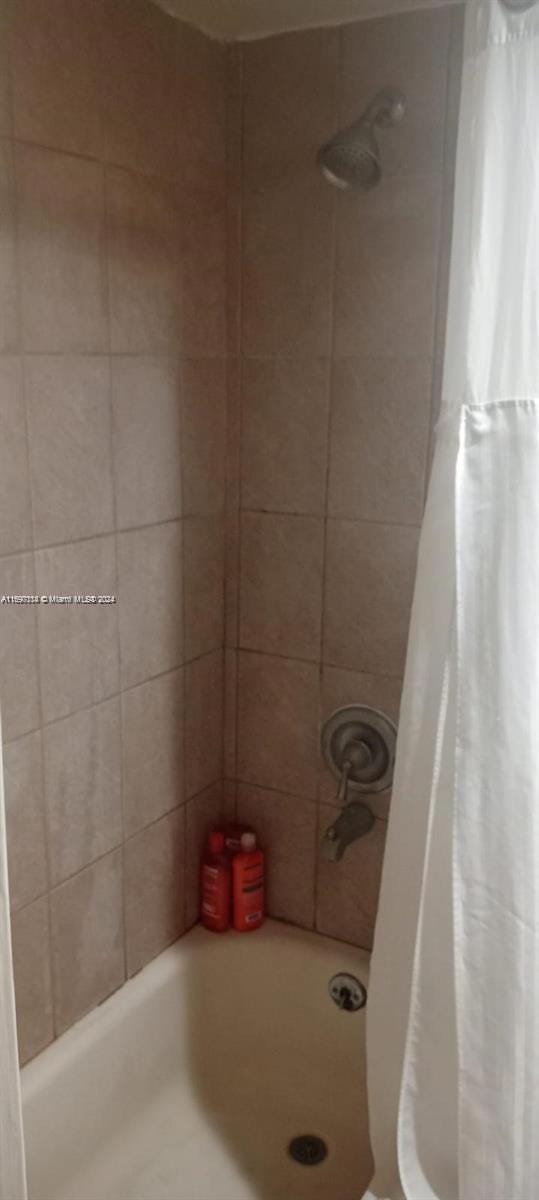 bathroom with shower / bath combo with shower curtain