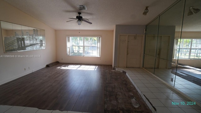 spare room featuring hardwood / wood-style flooring, ceiling fan, and a textured ceiling