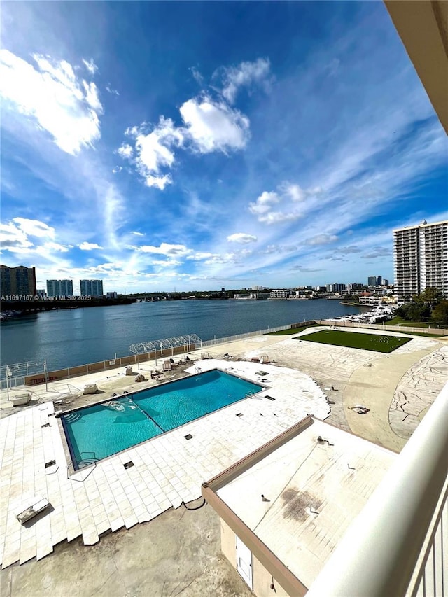 view of swimming pool with a water view and a patio area