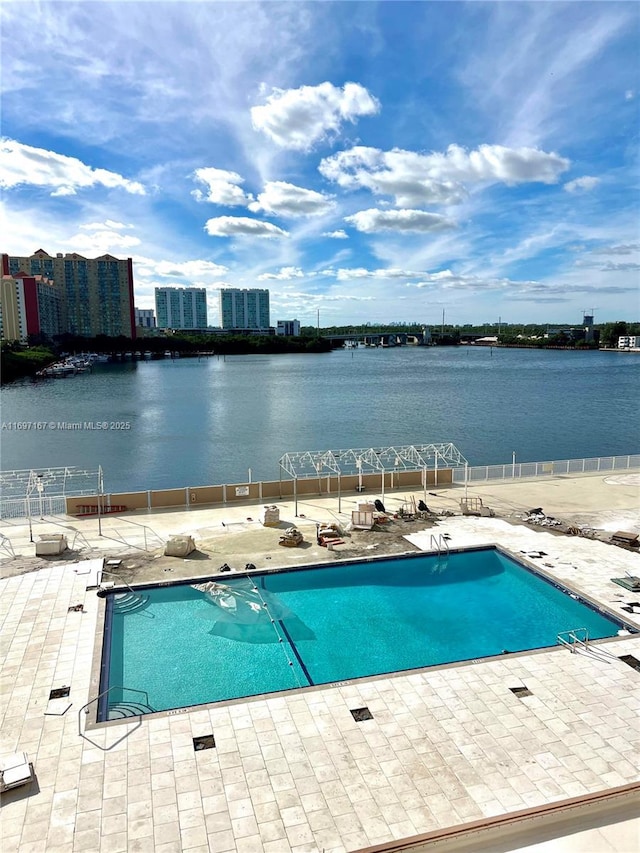 view of swimming pool featuring a water view and a patio