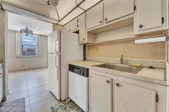 kitchen featuring tasteful backsplash, sink, light tile patterned floors, and dishwasher