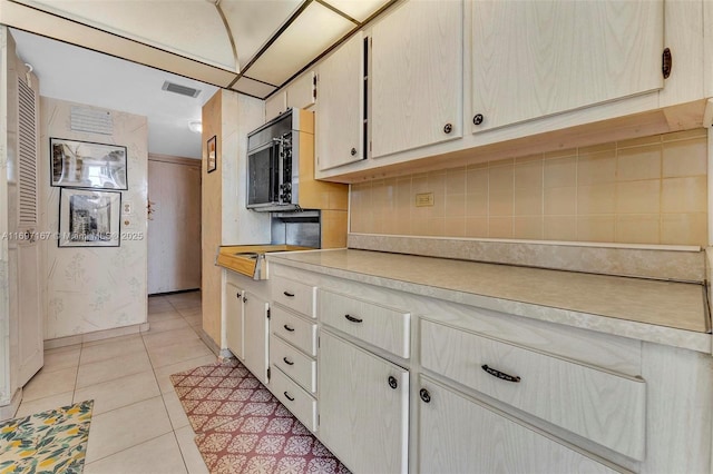 kitchen with tasteful backsplash and light tile patterned flooring