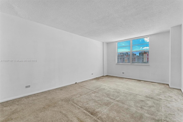 carpeted empty room with a textured ceiling