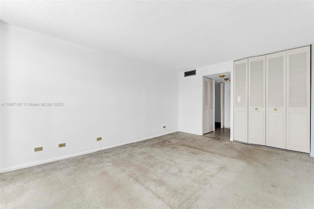 unfurnished bedroom with a textured ceiling and carpet flooring