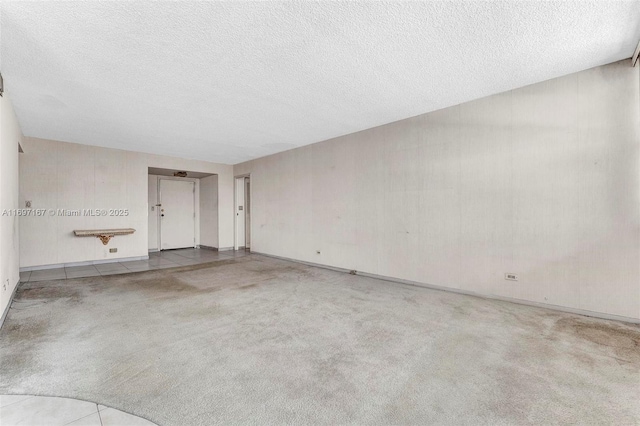 spare room with light carpet and a textured ceiling