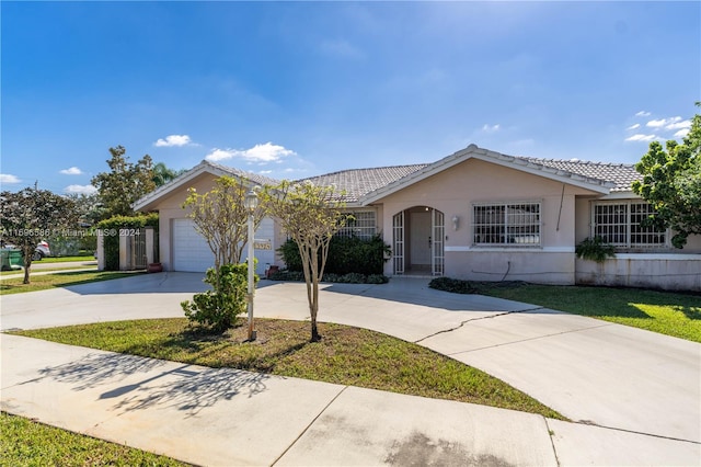 ranch-style house featuring a front lawn and a garage