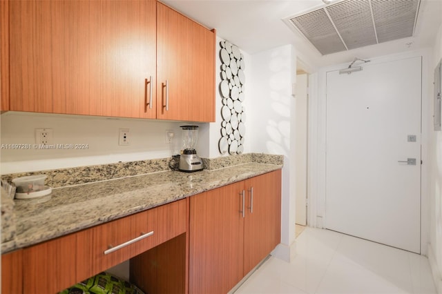 bar featuring light stone countertops and light tile patterned floors