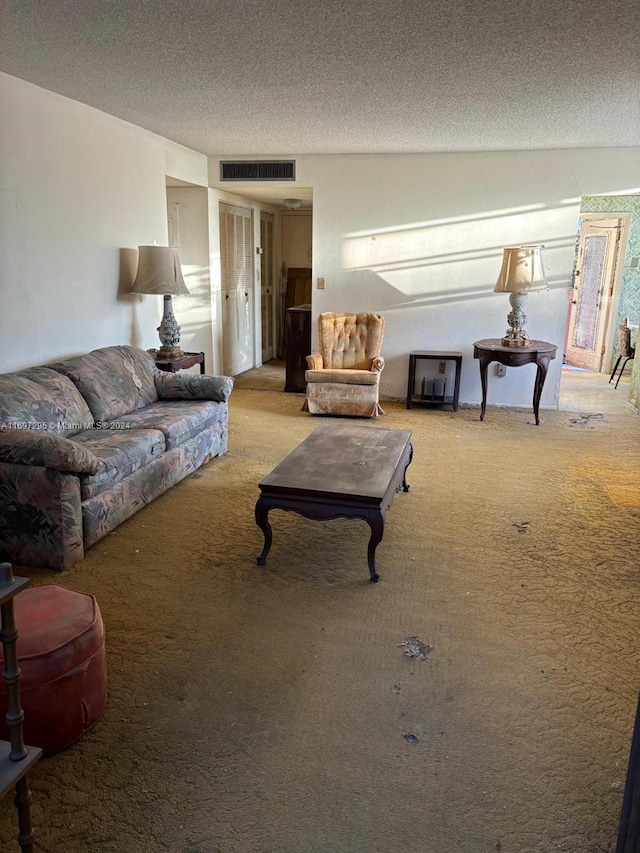 carpeted living room featuring a textured ceiling