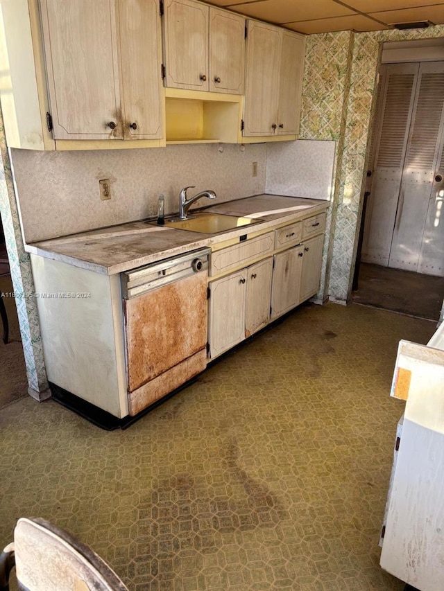 kitchen with dishwashing machine, a paneled ceiling, and sink