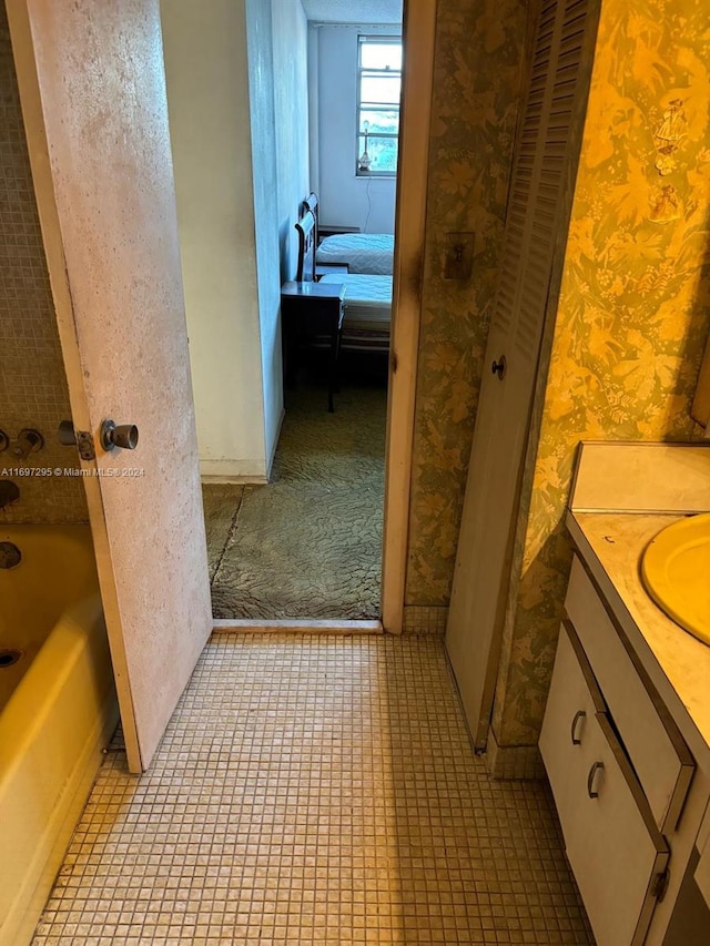 bathroom featuring tile patterned floors, vanity, and a tub