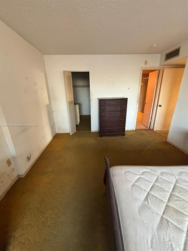 carpeted bedroom with a closet and a textured ceiling