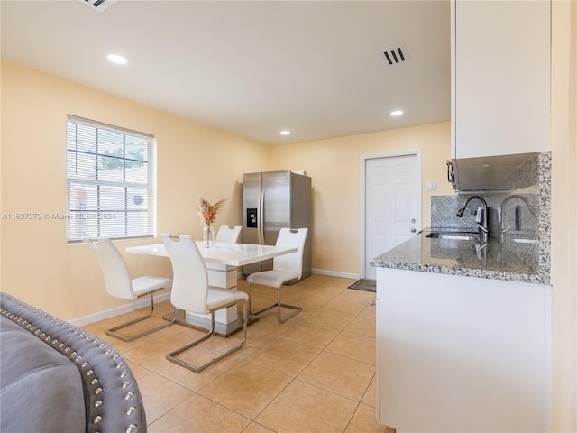 dining space featuring sink and light tile patterned floors